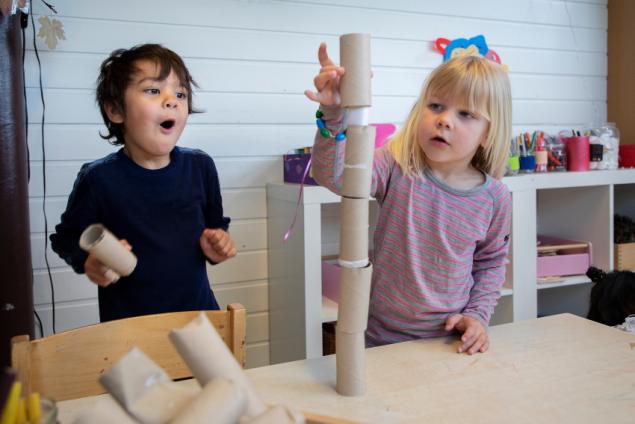 To barn bygger tårn med toalettruller